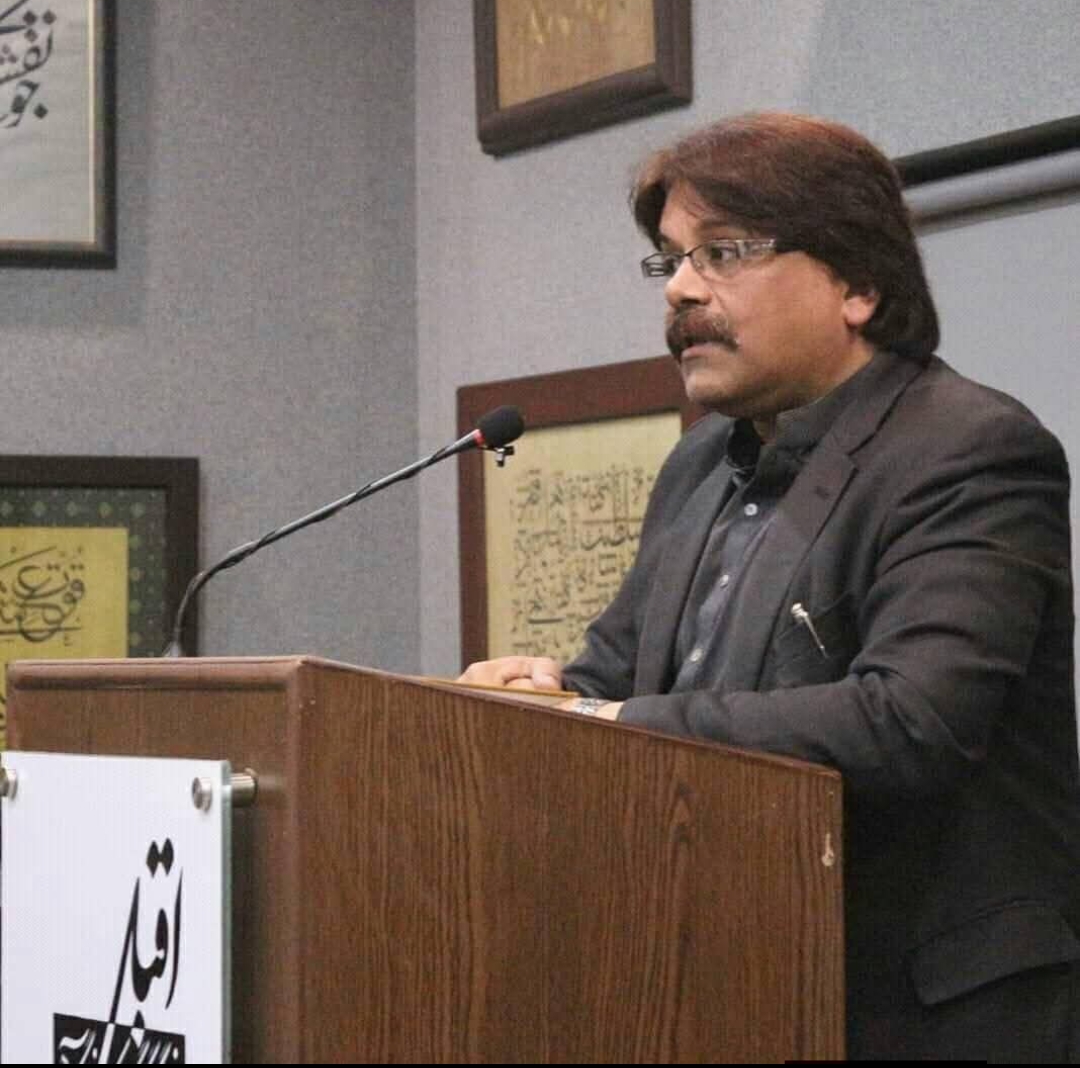 Dr. Jawwad speaking at a podium